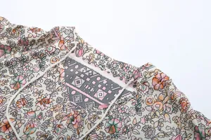 Detailed macro view of floral print V-neck with lace-up tassels and geometric inset