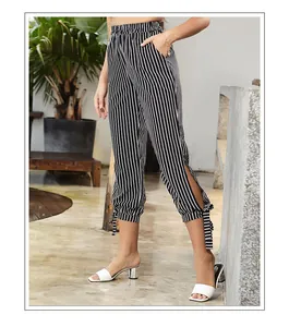 Detail of high waist striped cropped pants with side slits and decorative bows