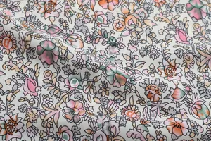Close-up of floral print fabric with vibrant orange and pink blossoms on lightweight material