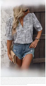 Dettaglio della camicia a maniche corte con scollo a V e motivo geometrico astratto
