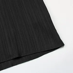 Détail du tissu noir de la robe montrant la texture rayée et les finitions de couture