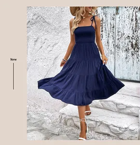Detailansicht des dunkelblauen gesmokten Oberteils und des Stufenrocks am Sommerkleid