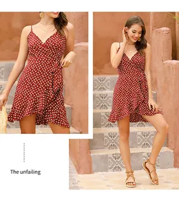 Detail of a brick red polka dot wrap dress featuring a V-neckline and ruffled hemline