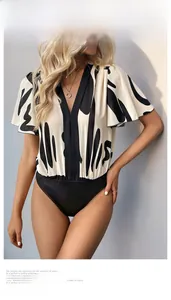 Detail of elegant V-neck bodysuit with abstract black prints and ruffled sleeve cuffs