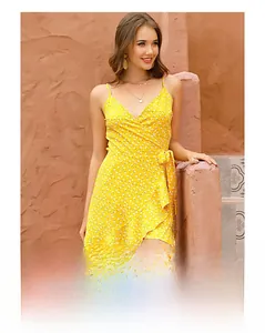 Detailed view of yellow floral wrap dress featuring V-neck straps and ruffled hem design