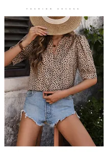 Detail of leopard print v-neck shirt with puff sleeves and frayed denim shorts