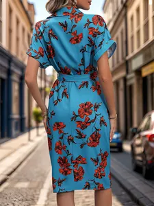 Blue short-sleeve shirt dress with orange floral print and waist tie shown from back view