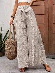 Detail of high waisted wide leg pants with ethnic print and drawstring bow tie waist