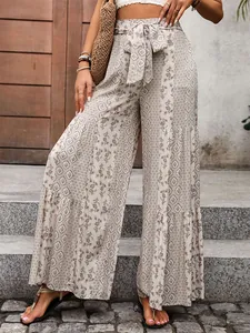 Detail of bohemian high-waist wide-leg pants with tiered patchwork and floral prints