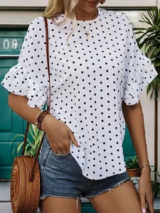 Detail of white polka dot blouse featuring layered ruffle sleeves and a round neckline