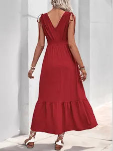 Detail of red backless maxi dress with shoulder bows and elegant ruffled hemline