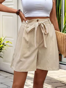 Detail of high-waisted wide-leg shorts featuring a self-tie bow belt in beige