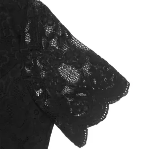 Close-up of delicate black floral lace fabric with intricate scalloped edge detail
