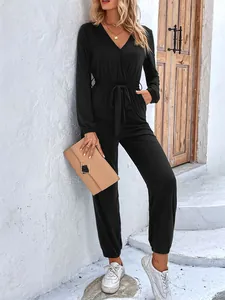 Detail of elegant black V-neck long sleeve jumpsuit with waist tie and elastic cuffs