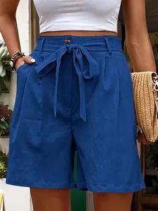 Detail of high-waisted royal blue shorts featuring a drawstring waist and side pockets