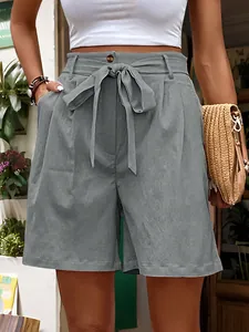 Detail of high waisted paperbag grey shorts with a tie belt and amber button