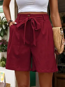 Detail of burgundy high-waisted shorts featuring a tie belt and soft corduroy texture