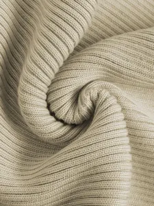 Makrodetail von elegantem beigem Strickgewebe mit weicher Textur und vertikalen Rippen