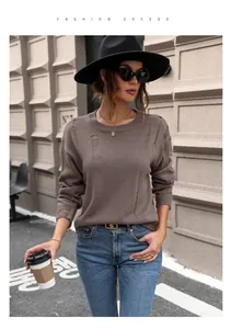 Detail of round neck brown sweater with distressed fringe and vintage knit texture
