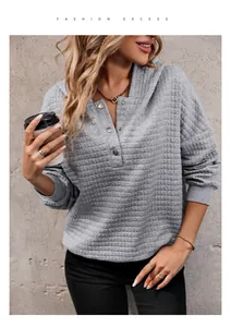 Detail of grey waffle knit hoodie featuring a Henley neckline with metallic buttons