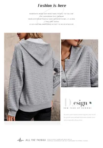Detail of waffle knit fabric and button neckline on a grey oversized long sleeve hoodie