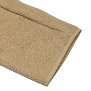 Close-up of khaki sherpa fleece fabric showing premium texture and reinforced hem detail