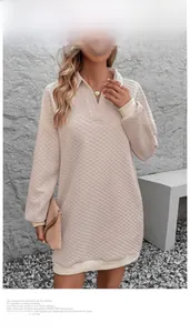 Detail of light beige V-neck quilted sweatshirt dress with ribbed cuffs and diamond texture