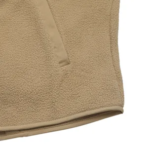 Detail of khaki fleece jacket featuring fluffy texture and a vertical zipper pocket