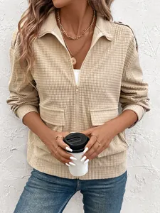 Detail of beige zip-up textured jacket featuring classic lapel and large utility pockets