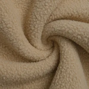 Close-up of the thick beige fleece texture and soft granular fabric of the short jacket