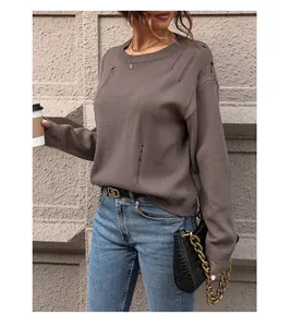 Detail shot of distressed knit texture and hollow-out design on brown crewneck sweater