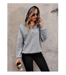 Detailed close-up of gray waffle knit texture and button neckline on women's hoodie