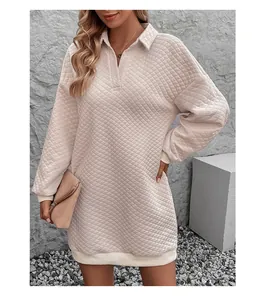 Detail of light pink quilted plaid dress featuring a relaxed V-neck and contrasting rib cuffs