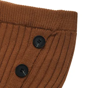 Detail shot of caramel brown ribbed knit fabric with two black decorative buttons