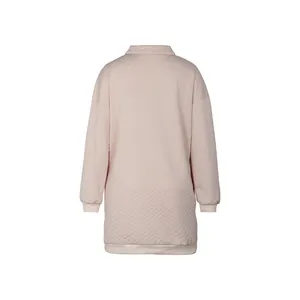 Detail of pink quilted V-neck sweater dress with diamond patterns and ribbed cuffs