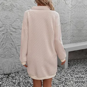 Back view of apricot quilted V-neck sweatshirt dress with loose fit and ribbed cuffs