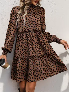 Detail of leopard print dress featuring high smocked neck and ruffled long sleeve cuffs