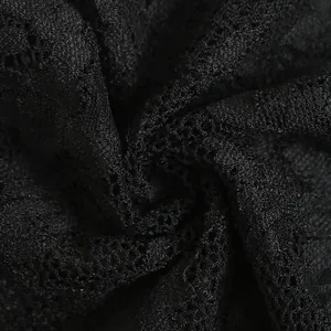 Close-up of intricate black lace fabric with delicate floral patterns and sheer texture