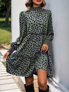 Detail of smocked cuffs and ruffled hem on a green floral long sleeve dress