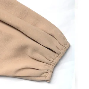 Detalle de blusa elegante color albaricoque con puños elásticos y costuras finas