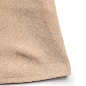 Detalle macro de la textura de tela albaricoque y dobladillo limpio de la blusa