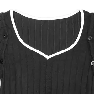 Dettaglio dello scollo a V in maglia a costine con bordo bianco e bottoni neri decorativi