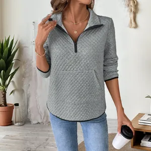 Detail of grey waffle knit pullover featuring a zip collar and large kangaroo pocket