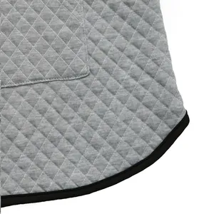 Macro detail of heather grey waffle knit fabric with diamond quilting and black elastic trim