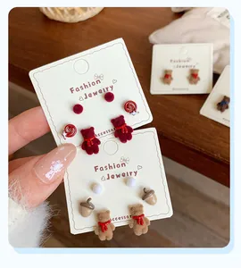 Close-up of winter bear stud earrings with fuzzy flocking and cute scarf details
