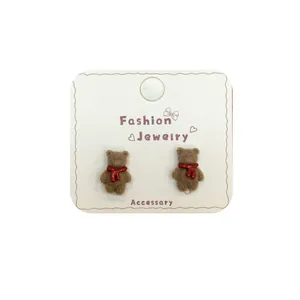 Cute brown flocked teddy bear stud earrings with red scarf on display card