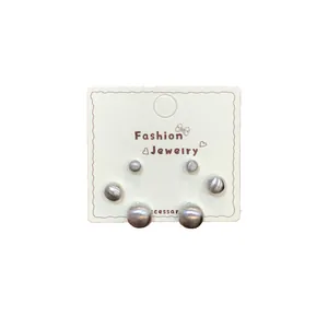 Three-pair set of matte silver spherical stud earrings in various sizes on display card