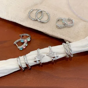 Silver hoop earrings collection with micro-pave zircons and star charms on fabric
