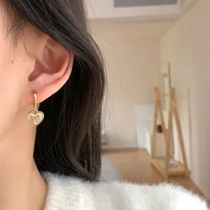 Elegant gold hoop earrings with cream heart charms and small golden bows for women