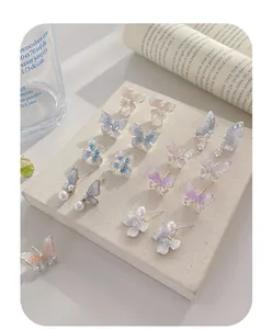 Detail showing gradient resin butterfly earrings with pearls and crystal accents
